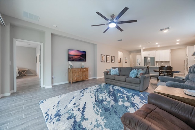 living room featuring ceiling fan and light hardwood / wood-style flooring