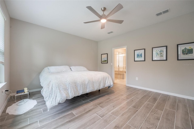 bedroom featuring hardwood / wood-style flooring, ceiling fan, and ensuite bath