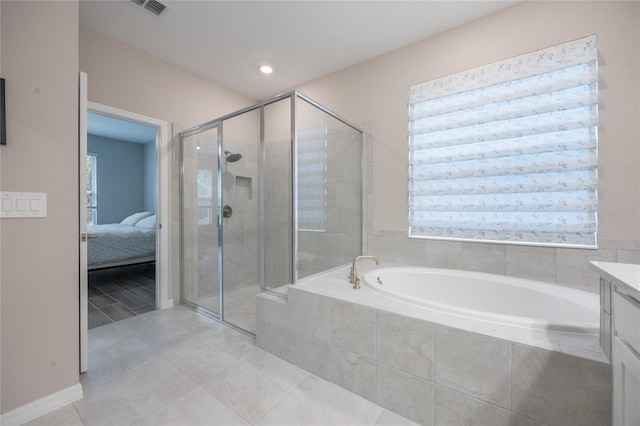 bathroom featuring plus walk in shower, vanity, tile patterned floors, and a wealth of natural light