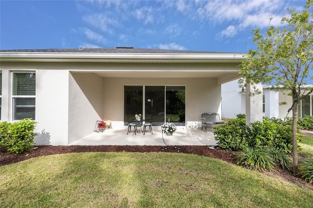 back of property with a yard and a patio