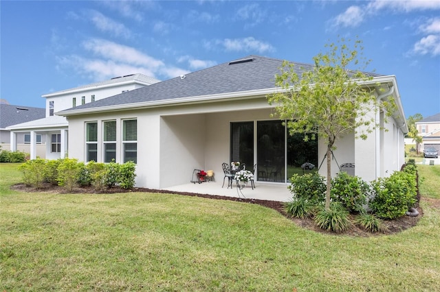 back of property with a patio area and a yard