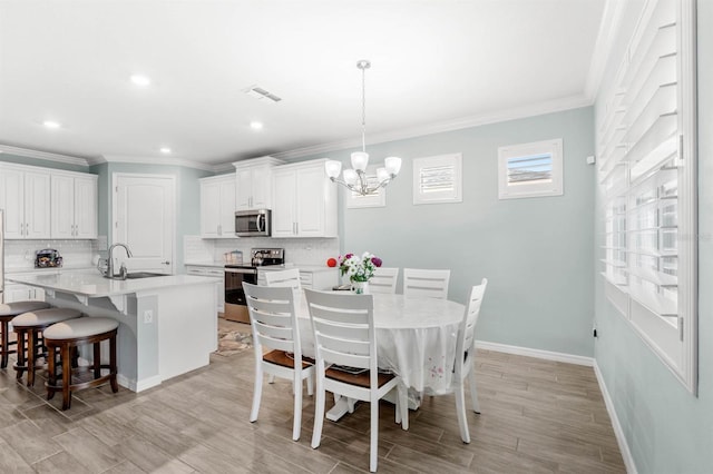 dining area featuring ornamental molding, a notable chandelier, and sink