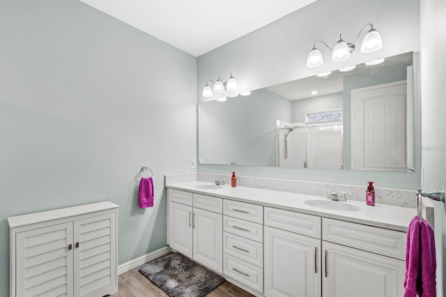 bathroom with vanity, a shower with shower door, and hardwood / wood-style flooring