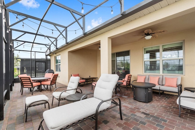 view of patio featuring glass enclosure, an outdoor living space, and ceiling fan