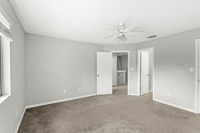 unfurnished room with ceiling fan and carpet floors