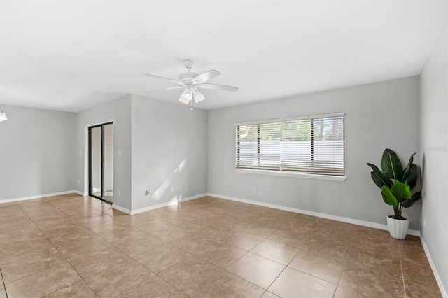 tiled spare room featuring ceiling fan