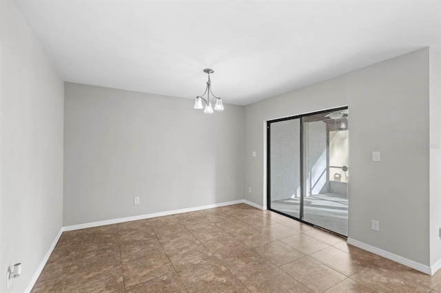 empty room with tile patterned floors and a chandelier