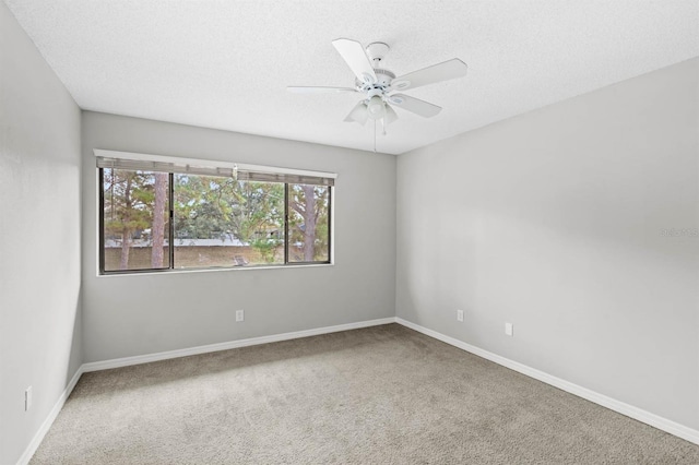 carpeted spare room featuring ceiling fan and a textured ceiling