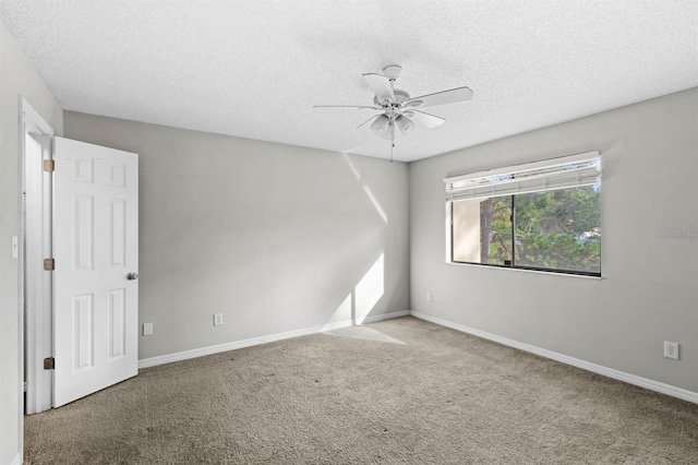 carpeted spare room featuring ceiling fan and a textured ceiling