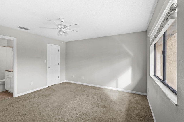 carpeted empty room featuring ceiling fan and a textured ceiling