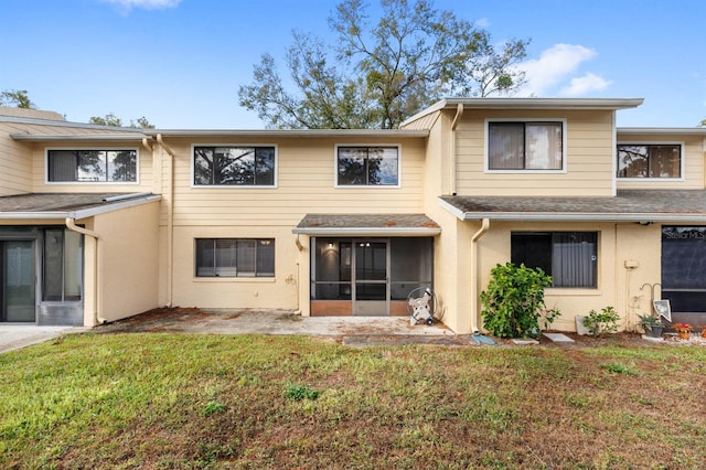 rear view of property with a sunroom and a yard