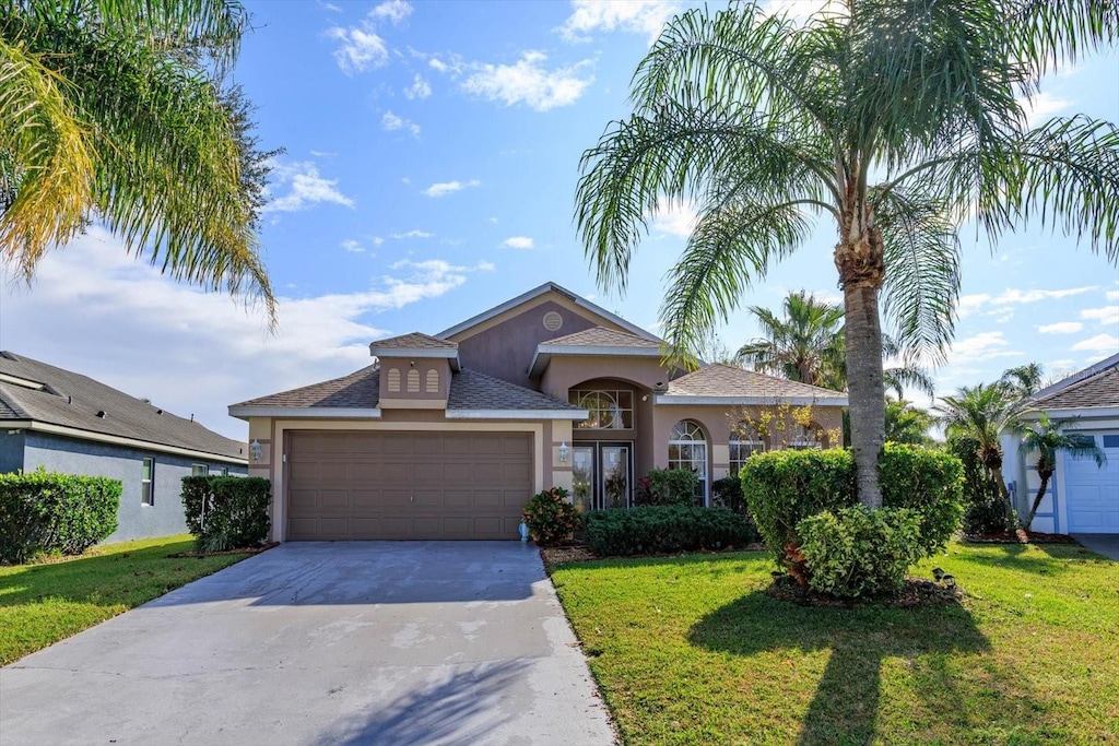 view of front of home with a garage and a front lawn