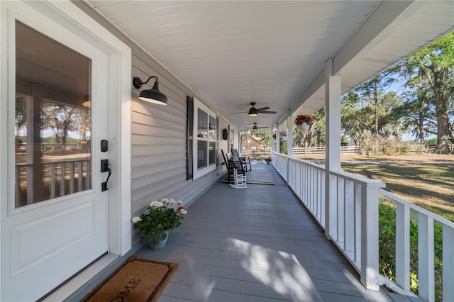 wooden terrace with a porch and ceiling fan