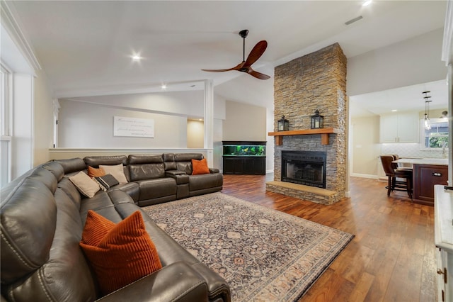 living room with hardwood / wood-style floors, ceiling fan, a fireplace, and vaulted ceiling