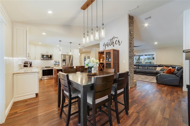 dining space with dark hardwood / wood-style flooring and lofted ceiling