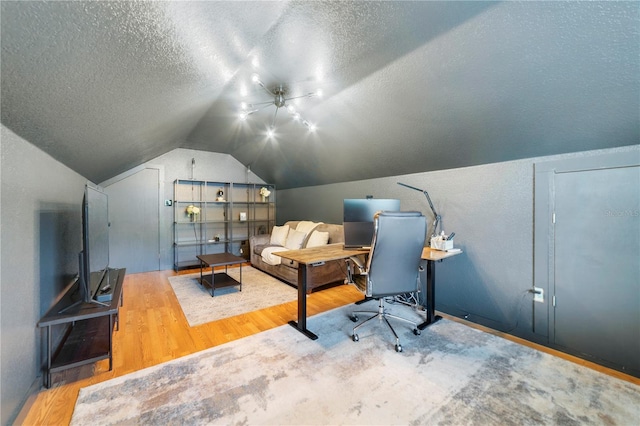 office featuring a textured ceiling, hardwood / wood-style flooring, ceiling fan, and lofted ceiling