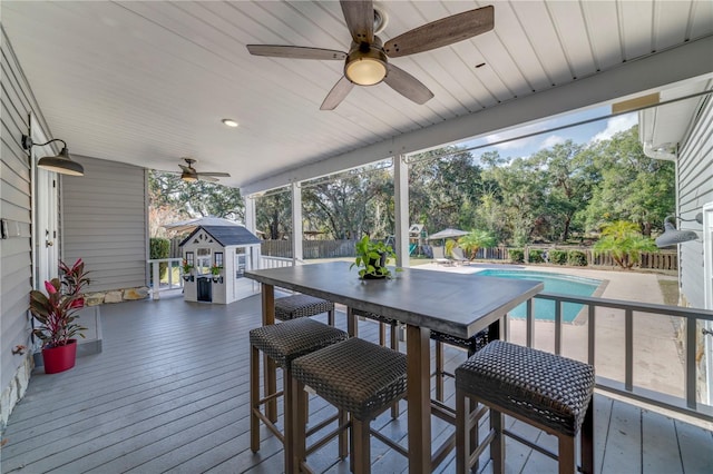 deck with a fenced in pool and an outbuilding