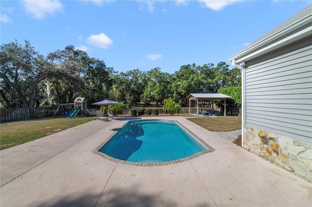 view of swimming pool featuring a gazebo, a playground, a patio, and a lawn