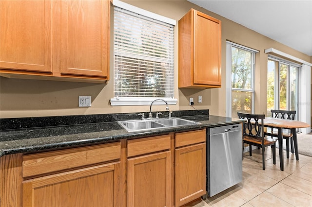 kitchen with dishwasher, light tile patterned floors, sink, and dark stone counters