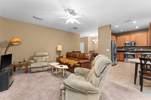 carpeted living room featuring ceiling fan with notable chandelier