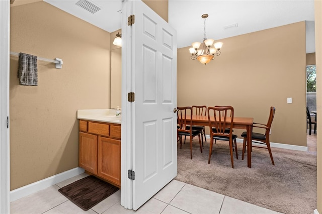 interior space with tile patterned flooring, vanity, and a chandelier