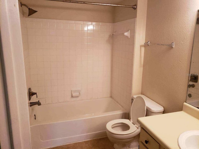 full bathroom with tile patterned floors, vanity, tiled shower / bath combo, and toilet