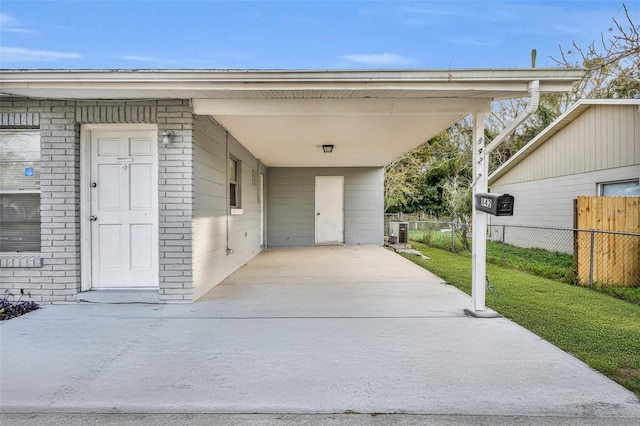 doorway to property featuring a carport, central air condition unit, and a lawn