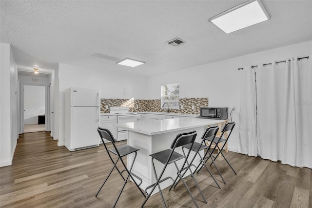 dining room featuring a textured ceiling, light hardwood / wood-style floors, and sink