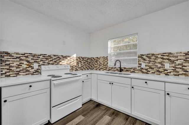 kitchen with a textured ceiling, dark wood-type flooring, sink, white cabinets, and white range with electric cooktop