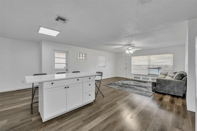 kitchen featuring a kitchen breakfast bar, white cabinetry, and a kitchen island