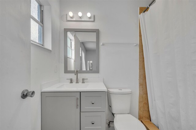 bathroom with a shower with shower curtain, vanity, and toilet