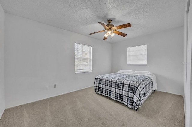 bedroom with carpet, ceiling fan, and a textured ceiling