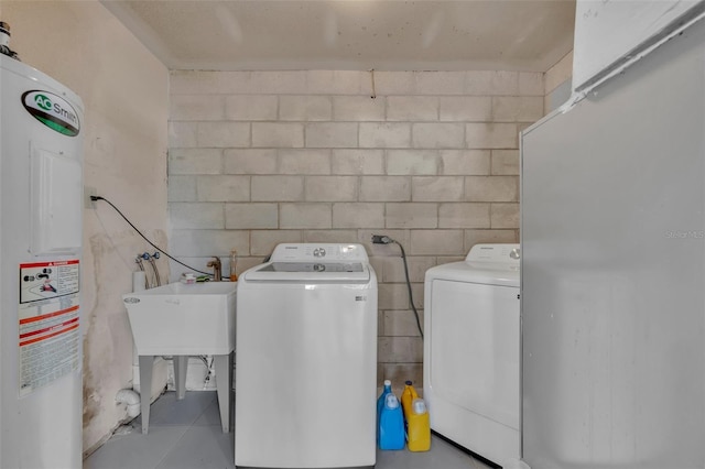 washroom featuring independent washer and dryer, sink, and water heater