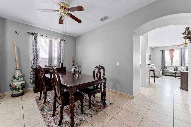 tiled dining room with ceiling fan, a healthy amount of sunlight, and a textured ceiling