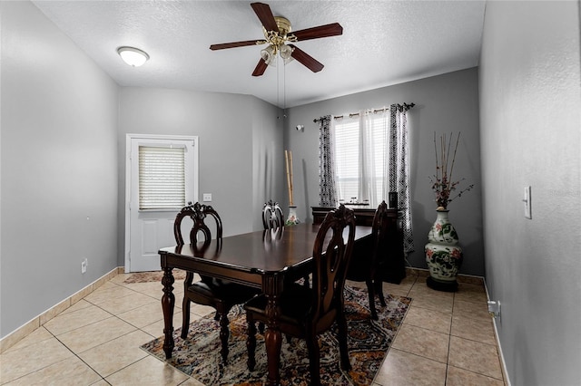 dining space featuring ceiling fan, light tile patterned floors, and a textured ceiling