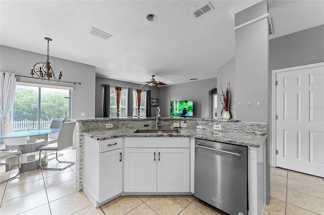 kitchen featuring ceiling fan with notable chandelier, sink, light tile patterned floors, dishwasher, and white cabinets