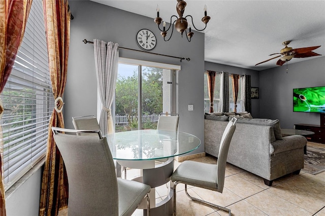 dining room featuring ceiling fan with notable chandelier and light tile patterned floors