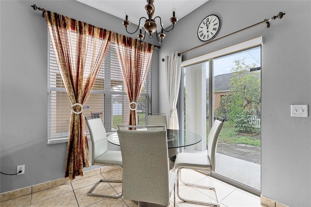 dining room featuring a wealth of natural light, light tile patterned flooring, and an inviting chandelier