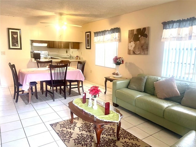 tiled living room featuring ceiling fan, sink, and a textured ceiling