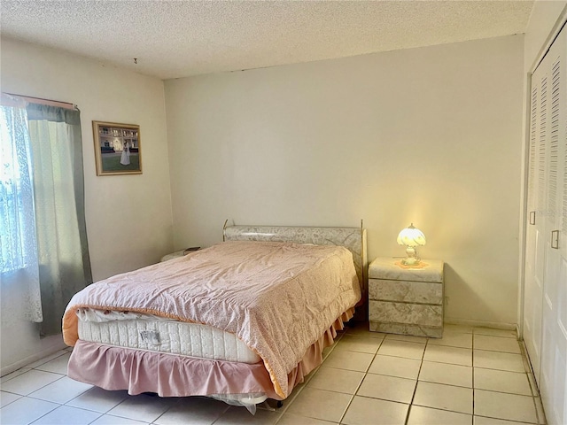 tiled bedroom featuring a textured ceiling and a closet