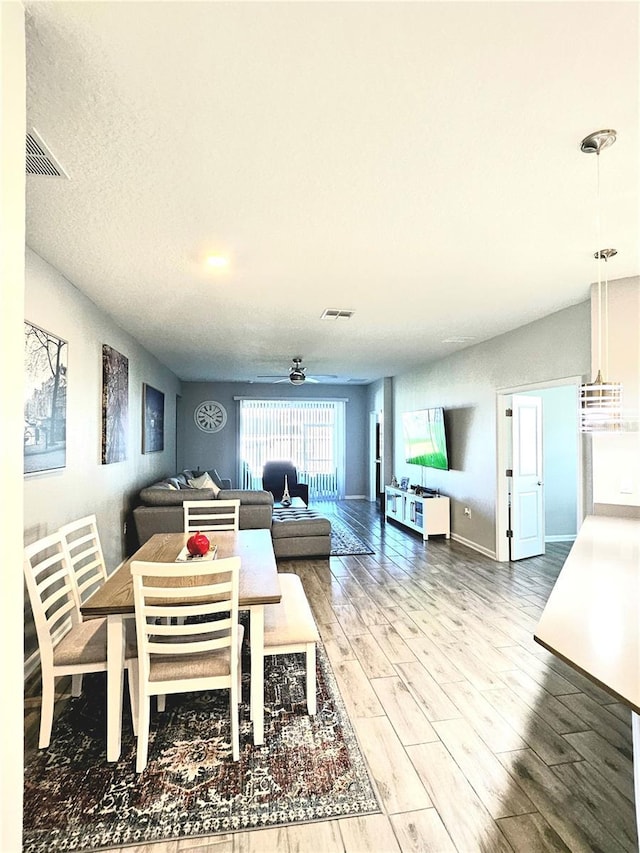 dining room featuring ceiling fan, a textured ceiling, and hardwood / wood-style flooring