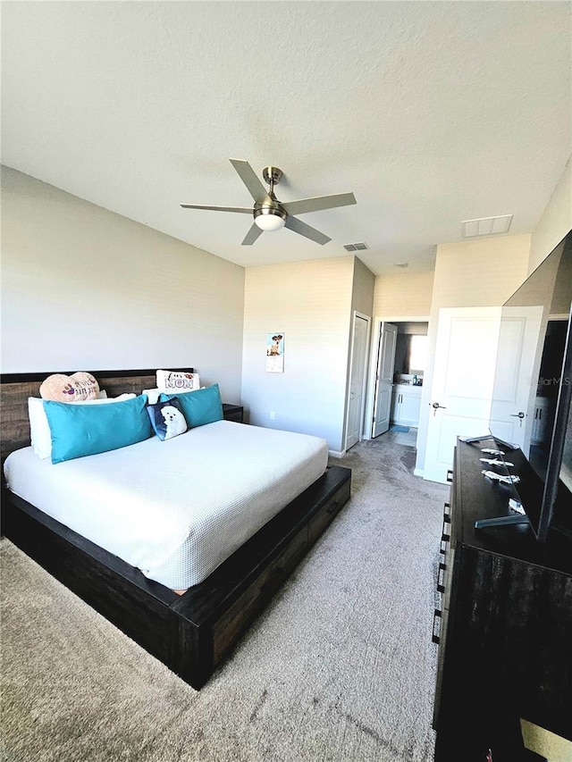 carpeted bedroom with a textured ceiling, a closet, and ceiling fan