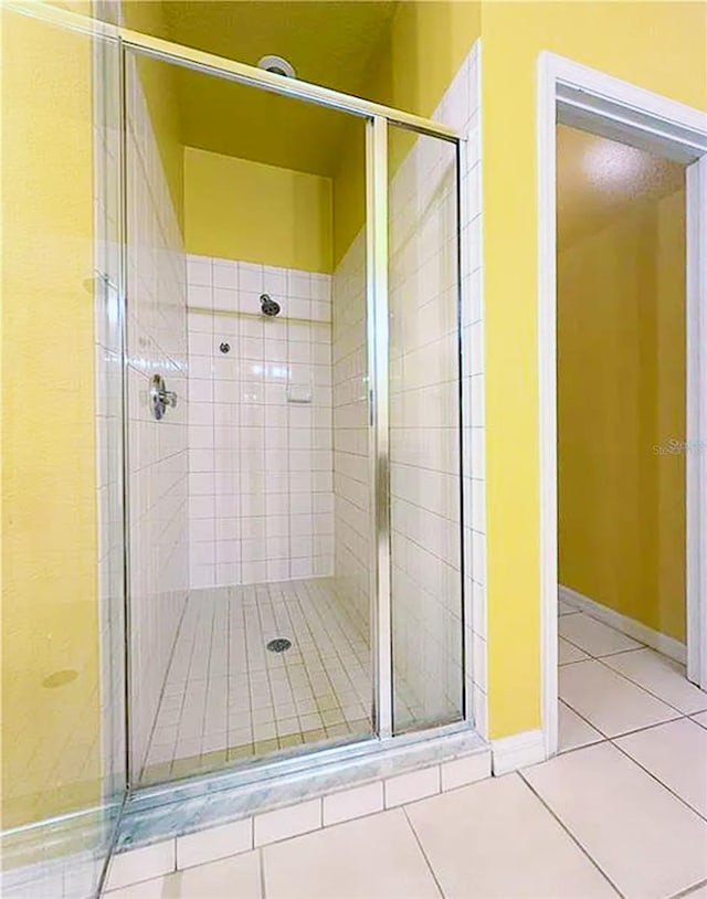 bathroom featuring a shower with shower door and tile patterned floors