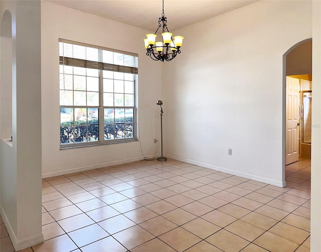 unfurnished room with an inviting chandelier and light tile patterned floors