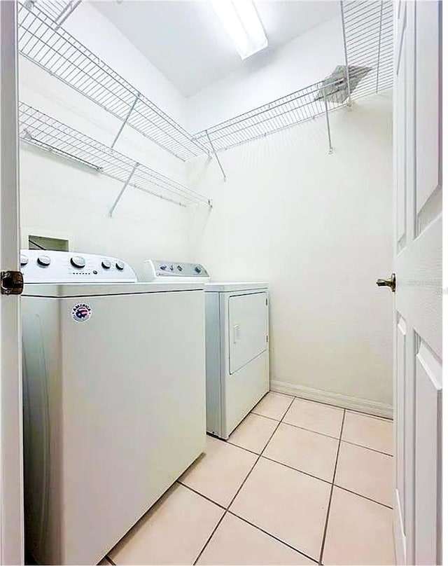 laundry area with light tile patterned floors and independent washer and dryer