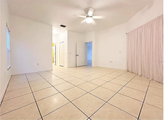 tiled spare room with ceiling fan