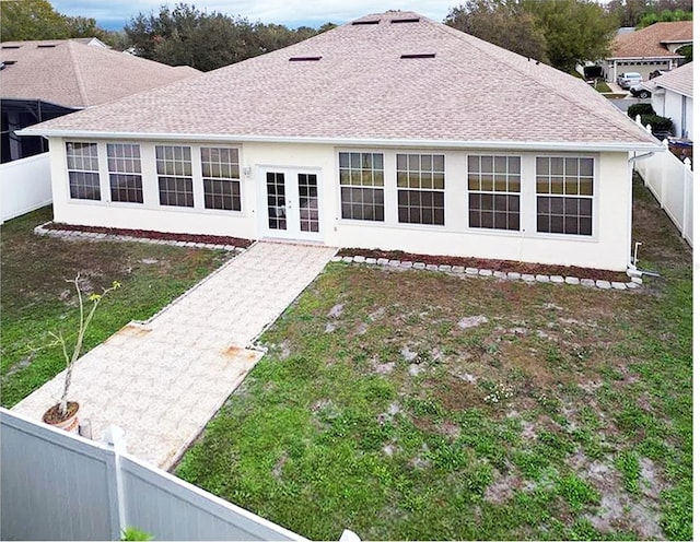 rear view of house featuring a yard and french doors