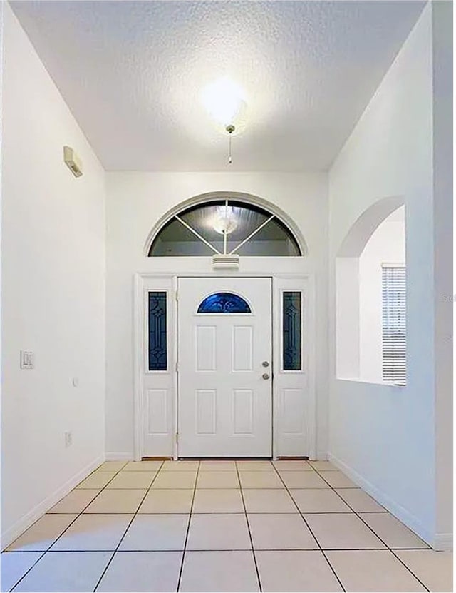 tiled entryway featuring a textured ceiling