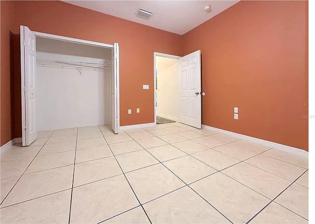 unfurnished bedroom featuring light tile patterned floors and a closet