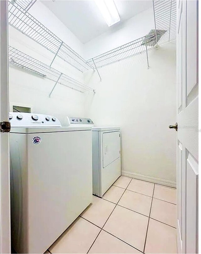 washroom with independent washer and dryer and light tile patterned flooring